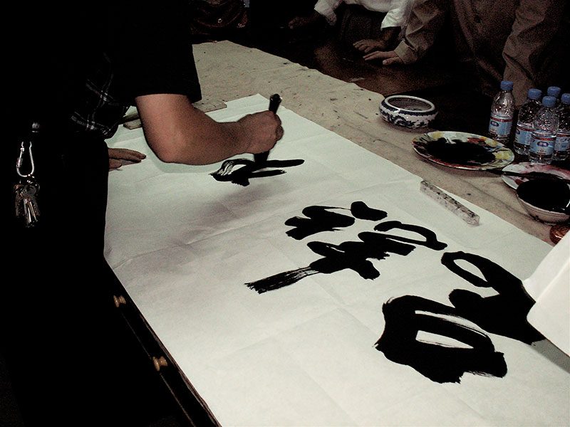 M. Cheng Yin Yue, me calligraphie ses souhaits de bonheur et de réussite avec un très gros pinceau.